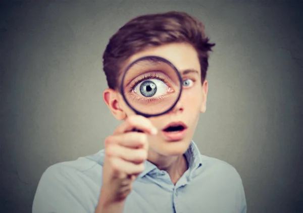 Curious amazed man looking through a magnifying glass — Stock Photo, Image