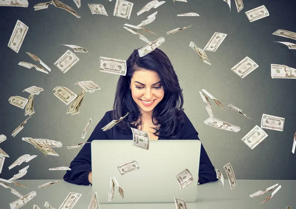 Mujer feliz utilizando un negocio en línea edificio portátil bajo billetes de dólar cayendo . —  Fotos de Stock