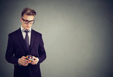 Rubik küp tutan gözlük ciddi adam portresi portre