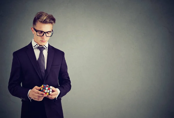 Retrato de primer plano de un hombre serio con gafas que sostiene el cubo de Rubik —  Fotos de Stock