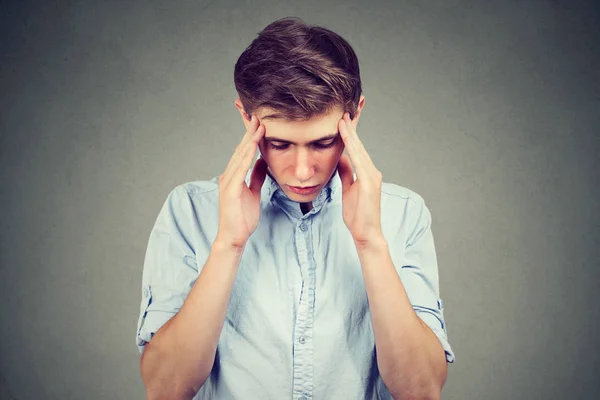 Triste joven guapo hombre con preocupado estresado expresión de la cara mirando hacia abajo — Foto de Stock