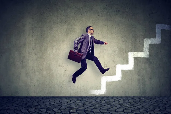 Ambitious business man climbing a staircase — Stock Photo, Image