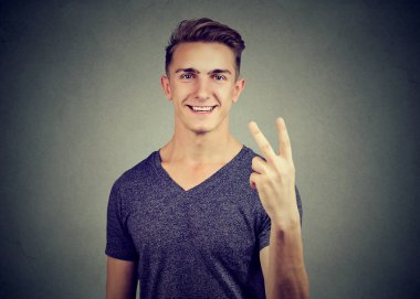 V-Sign gösterilen neşeli yakışıklı genç.