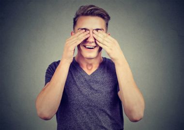 Göze hoş bir sürpriz beklentisiyle elleriyle genç adam 