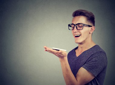 konuşma tanıma kavramı. eller serbest iletişim. Akıllı telefon kullanan genç adam 