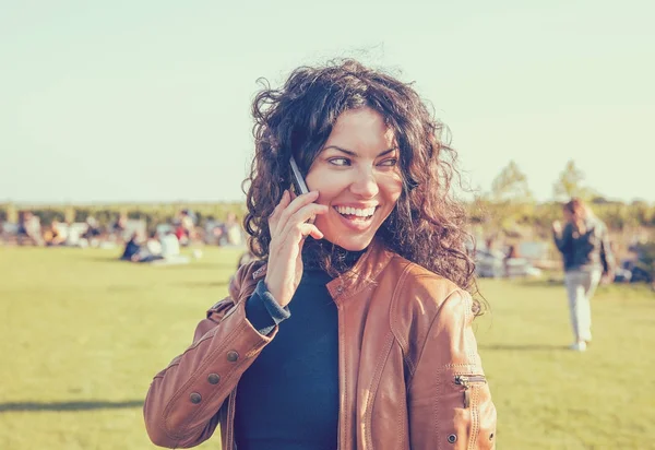Fiatal, boldog nő beszél a mobil telefon a szabadban. — Stock Fotó