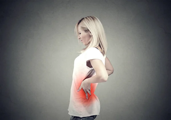 Mujer joven con dolor de espalda baja de color rojo — Foto de Stock