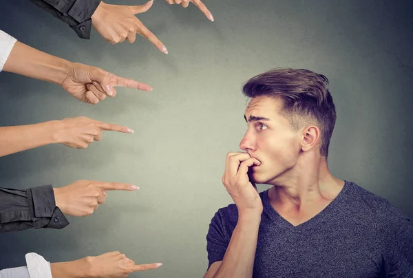 Anxious man judged by different people. Concept of accusation of guilty guy. — Stock Photo, Image