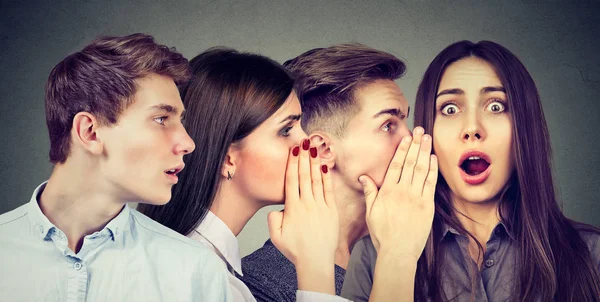 Groep van jonge mensen-mannen en vrouwen elkaar in het oor fluisteren. — Stockfoto