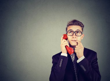 Yanlış anlama ve uzak çağrı. Üzgün endişeli şaşkın adam bir telefonda konuşurken pek çok soru vardır 