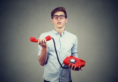 Kızgın genç adam eski moda telefon ile karışık