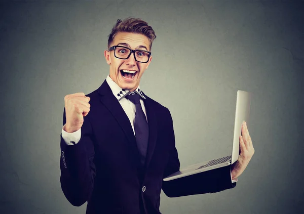 Joven exitoso usando el negocio en línea de construcción de computadoras portátiles celebrando el éxito . —  Fotos de Stock