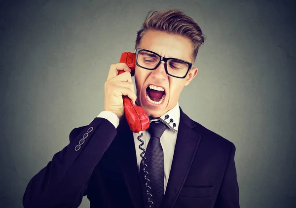 Rozhněvaný mladý obchodní muž křičí do telefonu — Stock fotografie