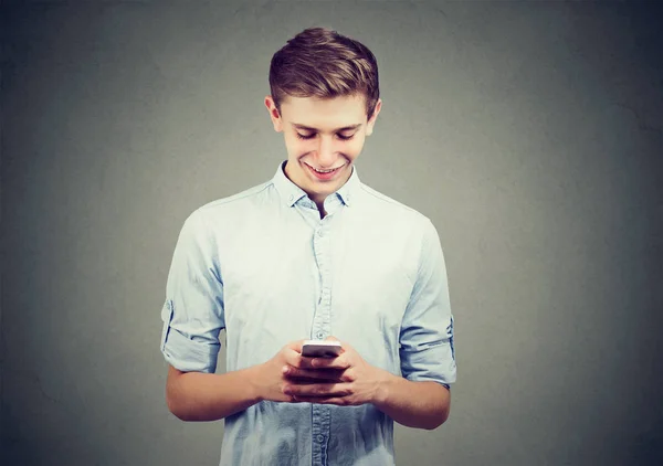 Stilig glad kille med en smartphone och ler — Stockfoto