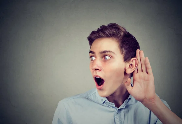 Amazed young man eavesdropping listening to latest rumor — Stock Photo, Image