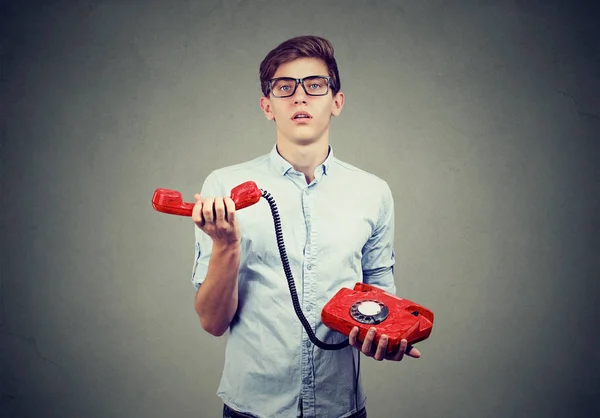 Confuso irritado adolescente homem com telefone à moda antiga — Fotografia de Stock