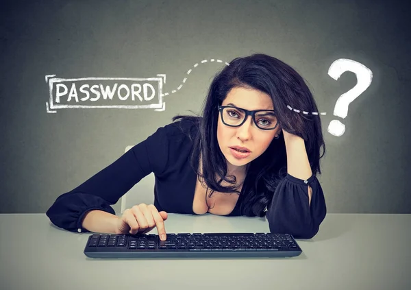 動揺の若い女性を自分のコンピューターにログインしようとすると、キーボードで入力するパスワードを忘れてしまった — ストック写真