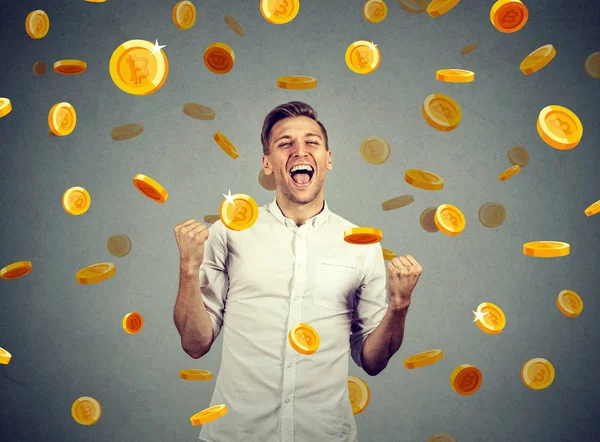 Ritratto di un giovane felice che celebra il successo finanziario sotto una pioggia bitcoin — Foto Stock