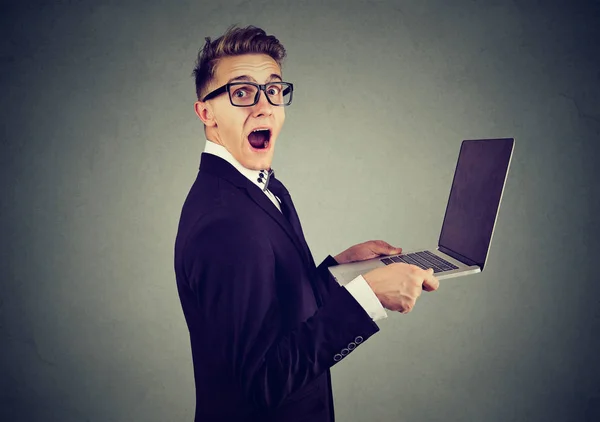 Surprised stunned man with laptop computer looking at camera Royalty Free Stock Photos