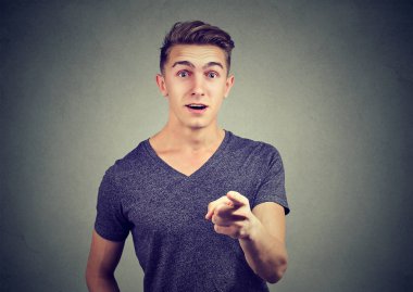 Şaşırmış yakışıklı genç adam işaret parmak kamera