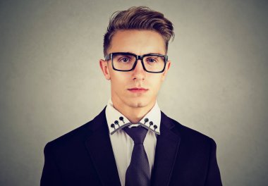 Gri arka plan üzerinde ciddi genç iş adamı portresi 