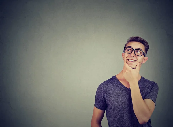 Bonito homem atencioso fazendo sua mente olhando para cima sorrindo — Fotografia de Stock