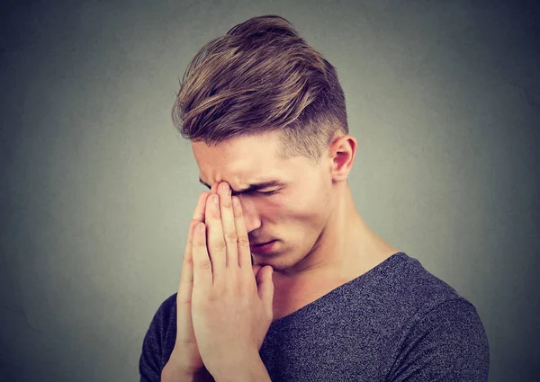 Sad young man with tensed face expression praying — Stock Photo, Image