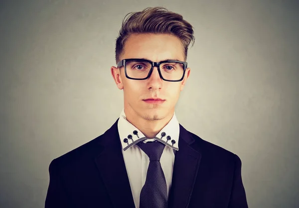 Portret van een serieuze jonge zakenman op grijze achtergrond — Stockfoto