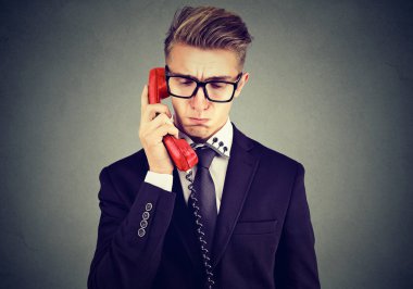 Üzgün yakışıklı adam hoş olmayan telefon konuşmayı aşağı bakıyor 
