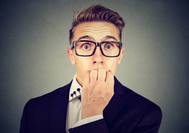 Kameraya bakarak tırnaklarını ısırma bardaklarda meşgul endişeli genç iş adamı 