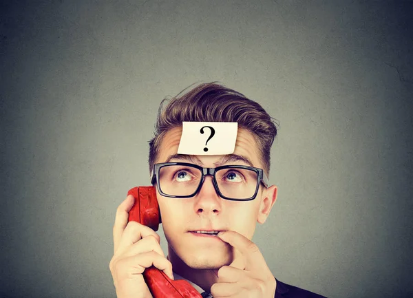 Perplexed man with question mark having a telephone conversation — Stock Photo, Image