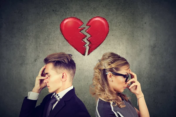 Rift in relations. Sad couple standing back to back with broken heart in-between — Stock Photo, Image
