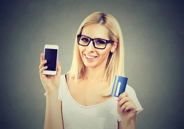 携帯電話やクレジット カードを持つ陽気な若い女性 — ストック写真