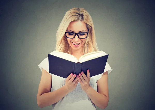 Porträt einer schönen jungen Frau mit Brille beim Lesen eines Buches — Stockfoto