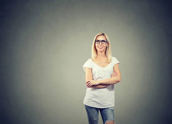 Mujer feliz pensando mirando hacia arriba mientras está de pie cerca de una pared de hormigón . —  Fotos de Stock