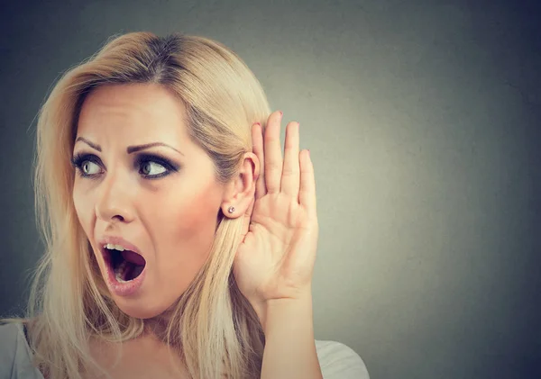 Geschokt vrouw houdt haar hand in de buurt van oor en luistert aandachtig — Stockfoto