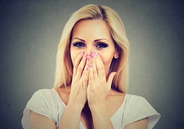 Portrait of a happy woman being shy laughing and covering face with hands