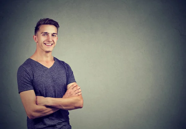 Casually handsome confident young man in t-shirt keeping arms crossed — Stock Photo, Image