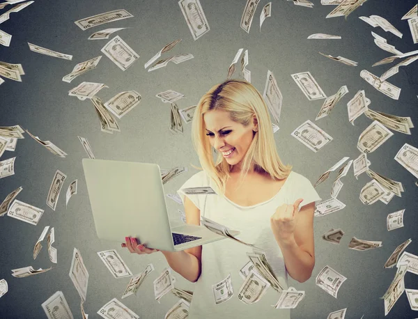 Mujer exitosa usando el negocio en línea del edificio del ordenador portátil que hace billetes del dólar del dinero que cae abajo . —  Fotos de Stock