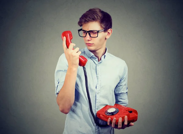 Confused worried man looking at old fashioned telephone — Stock Photo, Image