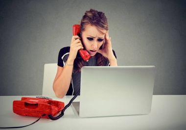 Genç kadın bir telefon masasında otururken dizüstü bilgisayar başında görünümlü: çağrı vurguladı 