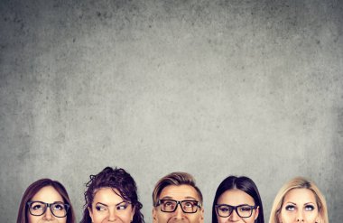 İnsanların kafaları ayakta gri beton duvara yakın closeup. Çeşitli iş takım ve beyin fırtınası kavramı 