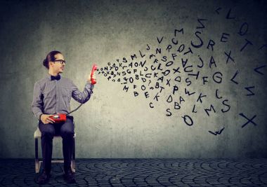 Telefon cep telefonu haber yaymak uçan alfabesi harfleri ile tutan genç iş adamı 