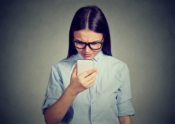 Portrait of upset sad serious woman talking texting on a phone displeased with conversation