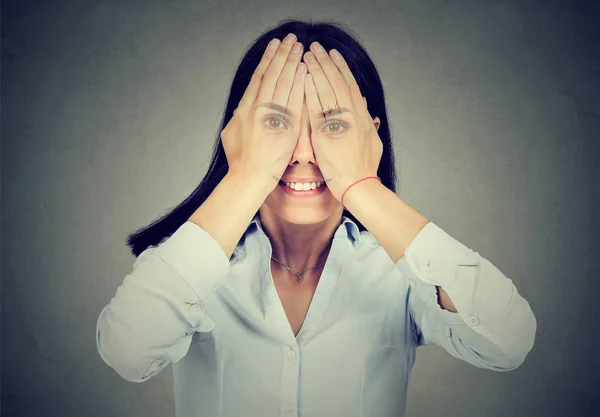 Portret van een lachende jonge vrouw voor haar ogen — Stockfoto