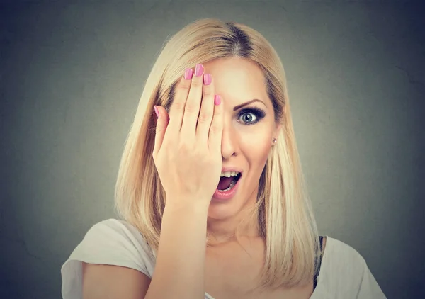 Mujer joven emocionada cubriendo uno ojos — Foto de Stock