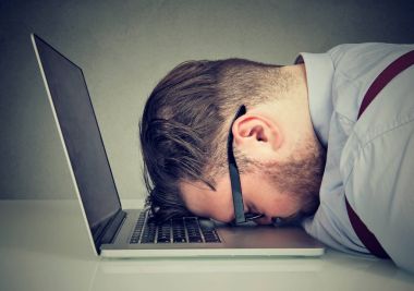 Overworked man lying on laptop clipart