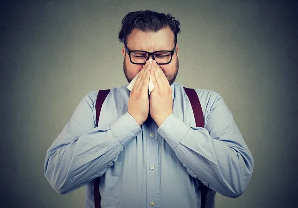 Dikke man die zich voordeed op grijs niezen — Stockfoto