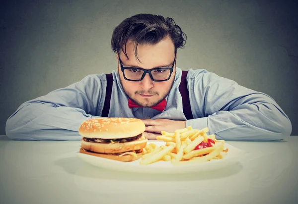 Homem ansioso sobre fast food pouco saudável — Fotografia de Stock