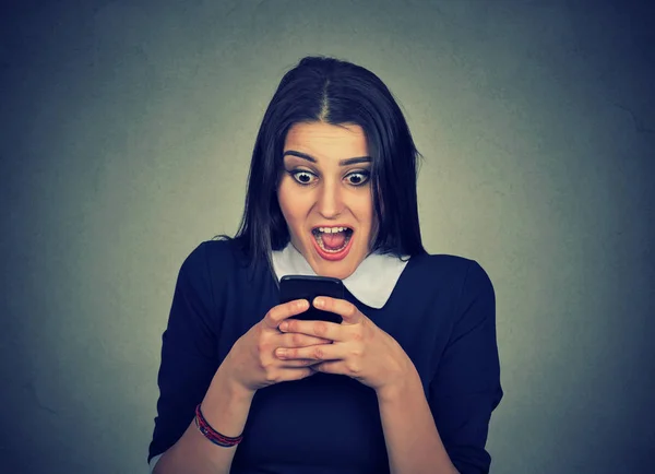 Шокированная женщина смотрит мобильный телефон — стоковое фото